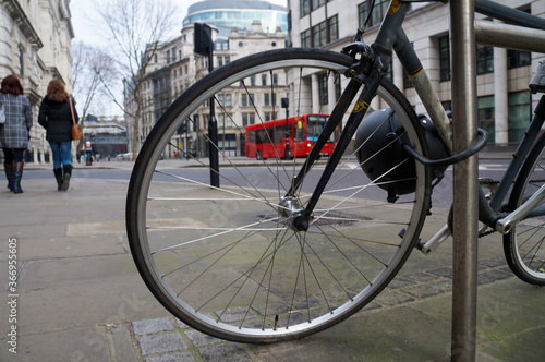 Bicycle wheel and red bus on London street