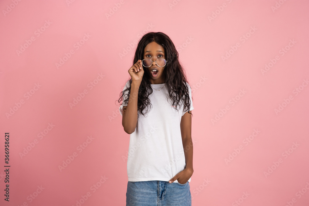 Shocked. Cheerful african-american young woman isolated on pink background, emotional and expressive. Concept of human emotions, facial expression, sales, ad. Beautiful model with long curly hair. Shocked. Cheerful african-american young woman isolated on pink background, emotional and expressive. Concept of human emotions, facial expression, sales, ad. Beautiful model with long curly hair.