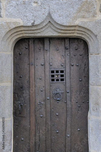 Ancient celtic wooden door with metallic peekhole