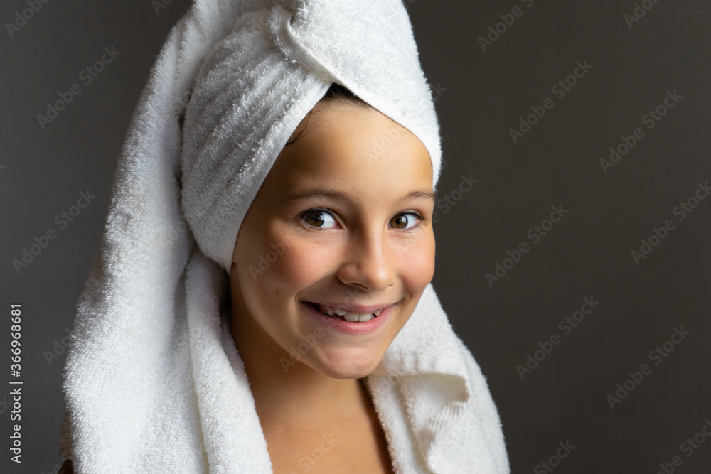 Obraz premium Cute little girl happy smiling after spa bath on a white bath towel head