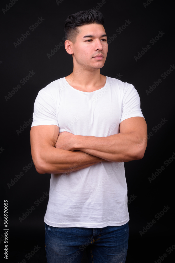 Young handsome multi ethnic man against black background Young handsome multi ethnic man against black background