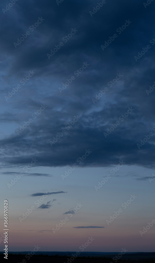 Rain in the forest. Storm clouds against a blue sky. The sun is hidden. Panorama. Tragic gloomy sky. Fantastic skies on the planet earth. Twilight, nightfall. Rain in the forest. Storm clouds against a blue sky. The sun is hidden. Panorama. Tragic gloomy sky. Fantastic skies on the planet earth. Twilight, nightfall.