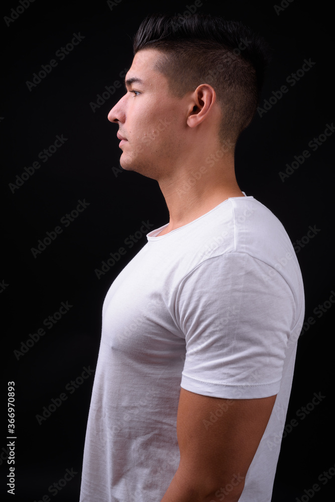 Young handsome multi ethnic man against black background Young handsome multi ethnic man against black background