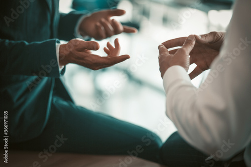 Fotografía Two business people have conversation sitting on office desk