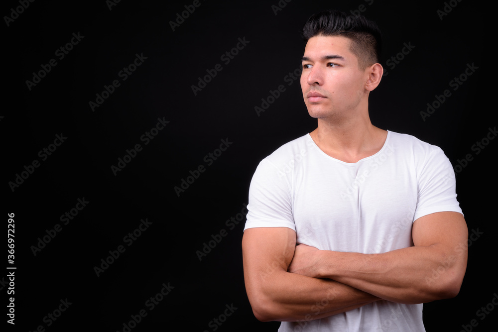 Young handsome multi ethnic man against black background Young handsome multi ethnic man against black background