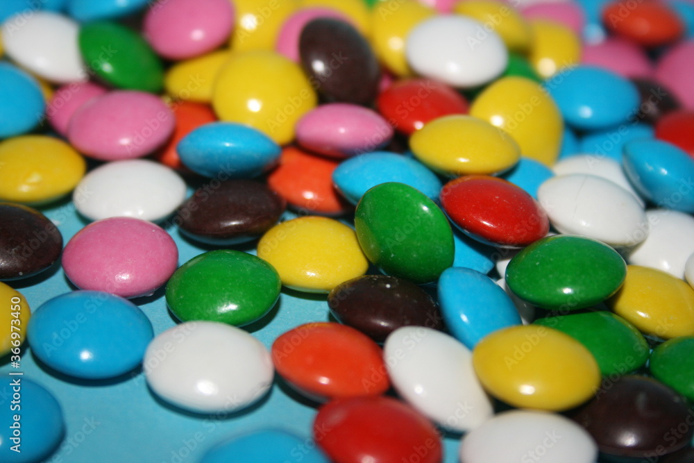 multicolored delicious candies with chocolate on a blue background