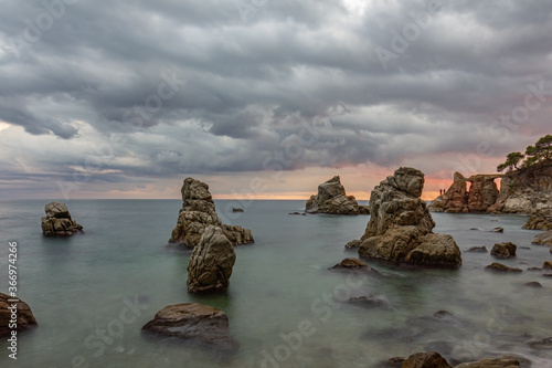 atardecer en el mar con rocas de formas curiosas y cielo nublado