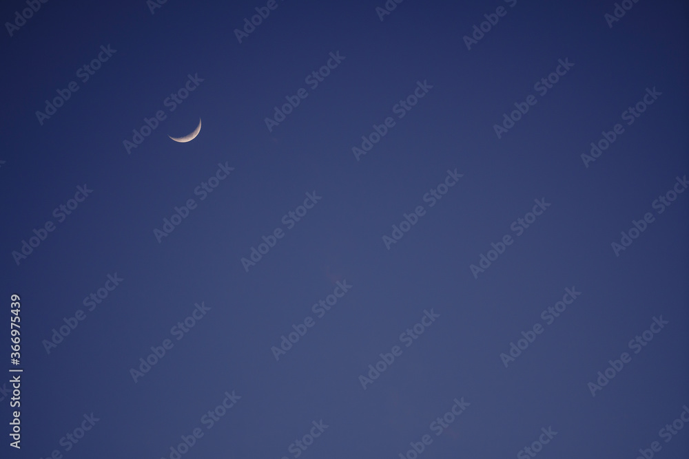 Crescent moon in the dusk with blue sky Crescent moon in the dusk with blue sky