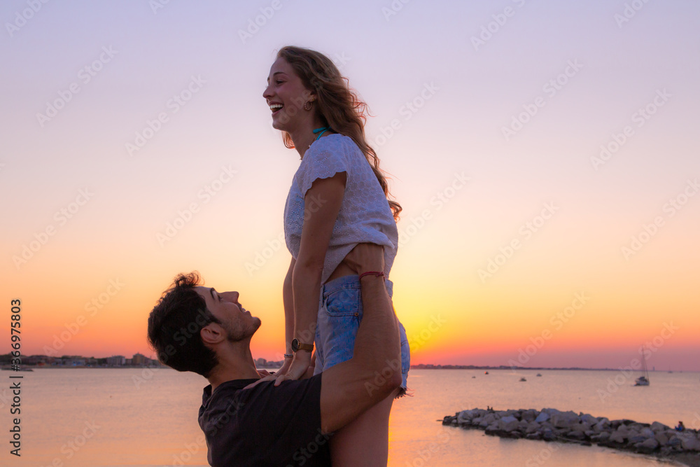 Fototapeta premium young couple of lovers having fun in the sunset light
