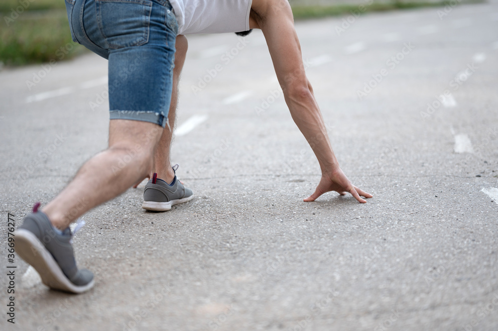 Athlete at the start before running on the running road on the street Athlete at the start before running on the running road on the street