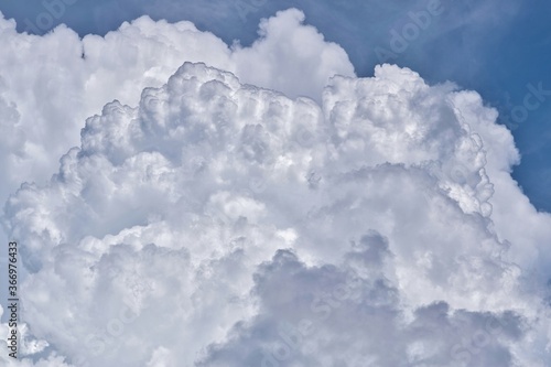 Towering Cumulus clouds forming in the sky before the onset of a thunderstorm in a tropical climate.