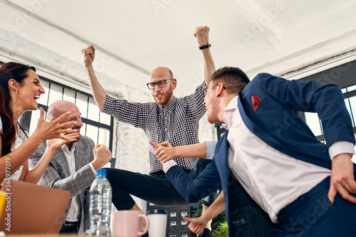 Excited diverse business team employees screaming celebrating good news business win corporate success  happy multi-ethnic colleagues workers group feeling motivated ecstatic about great achievement
