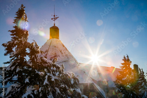 A lodge on the slopes of Mt Hood with a sunburst, Oregon, Mt Hood National Forest.