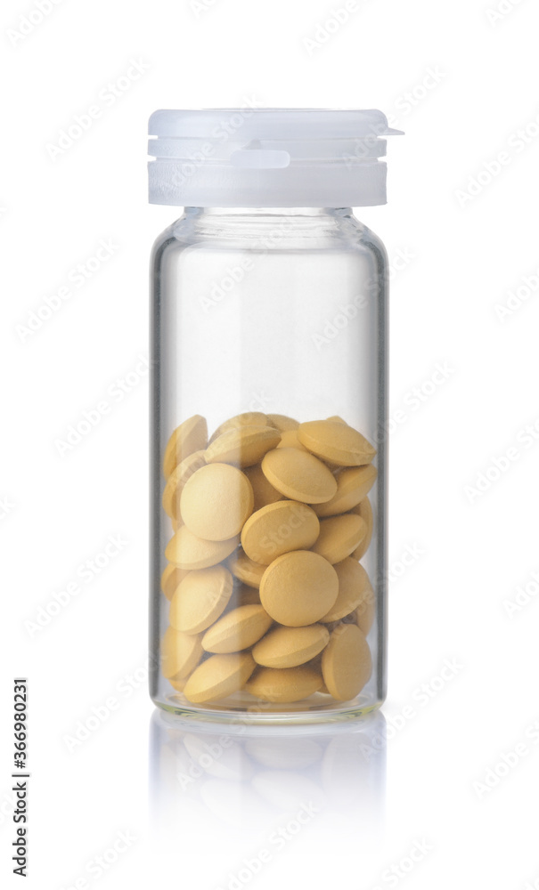 Front view of clear glass bottle with yellow pills Front view of clear glass bottle with yellow pills