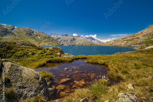 Swiss alps pass in summer with lake and blue sky
