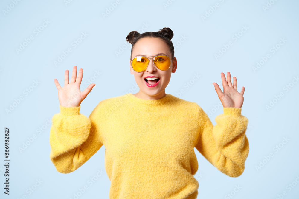young happy woman in yellow sweater and glasses on blue background young happy woman in yellow sweater and glasses on blue background