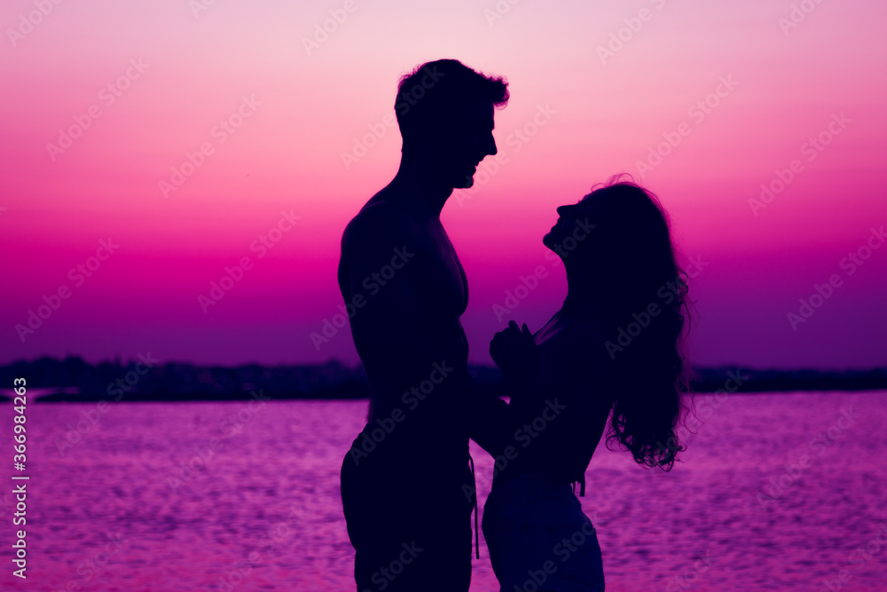 Silhouette of couple in love in the sunset beach