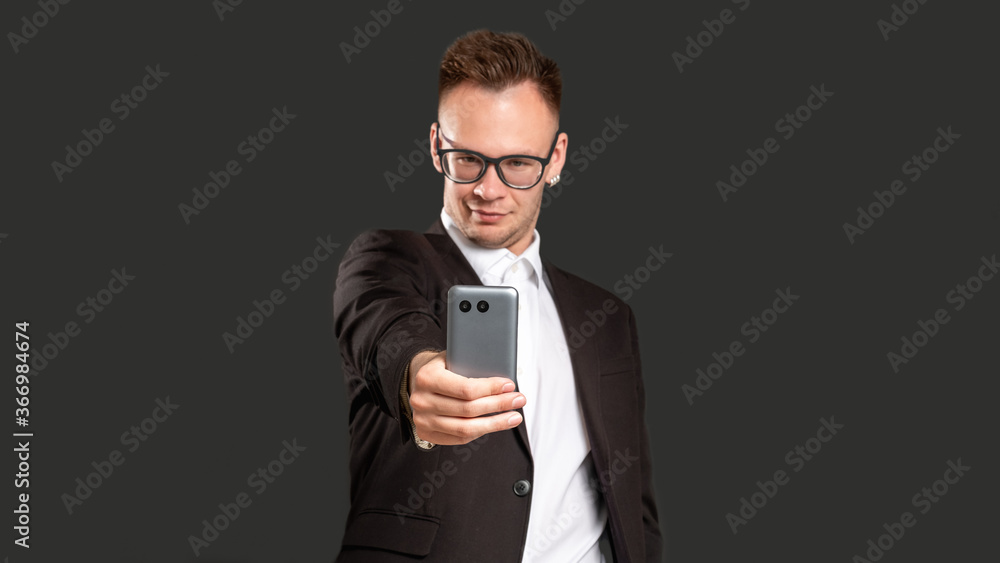 Social media addiction. Modern technology. Confident business man taking selfie on phone isolated on black copy space blur background. Online communication. Mobile app. Social media addiction. Modern technology. Confident business man taking selfie on phone isolated on black copy space blur background. Online communication. Mobile app.