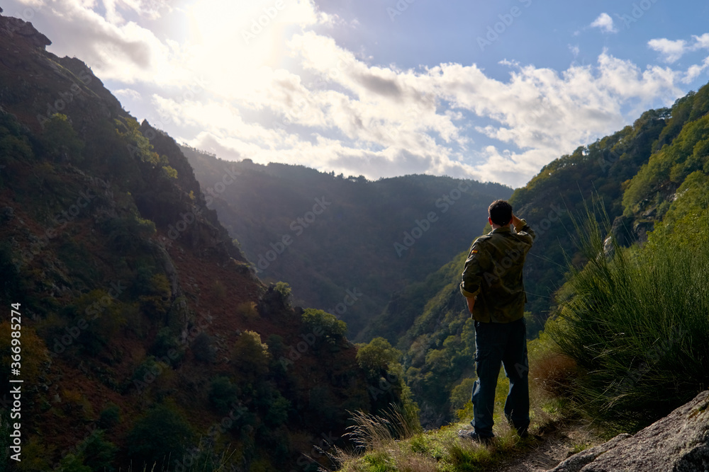 Man looking at a valley in autumn