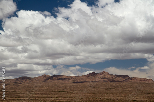 Arid landscape. View of the desert and rocky mountains under a dramatic sky with beautiful clouds.   