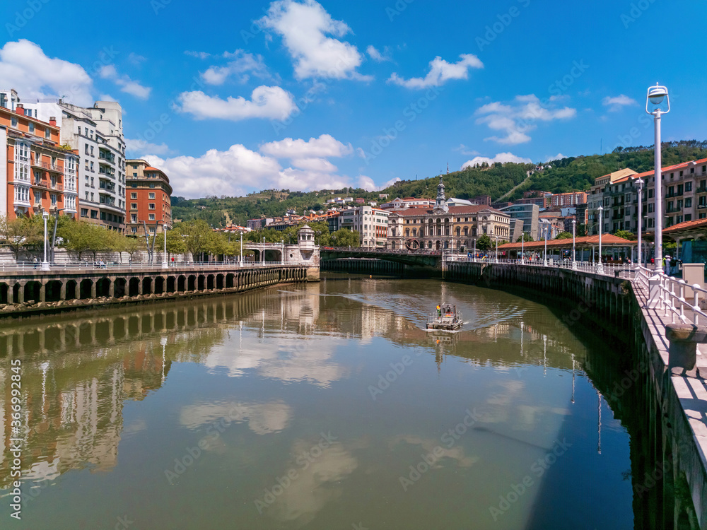 Bilbao estuary with the Town Hall Bridge in the background and a water service boat