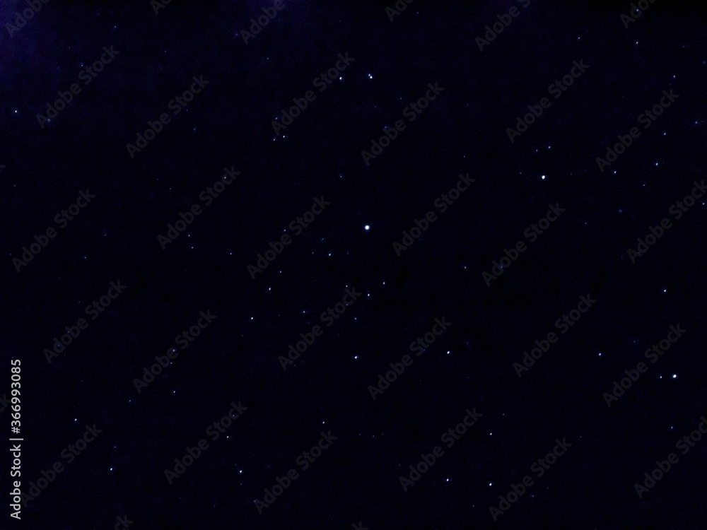 Fototapeta premium Flying dust particles on a black background. Stars in summer days 