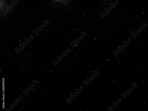 Flying dust particles on a black background. Stars in summer days 