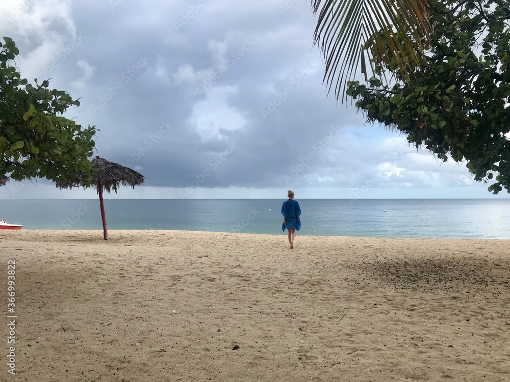 Obraz premium Pretty blonde female model on the sandy beach of Playa Ancon in Cuba in a panorama of a tropical paradise enjoying her relaxing vacation
