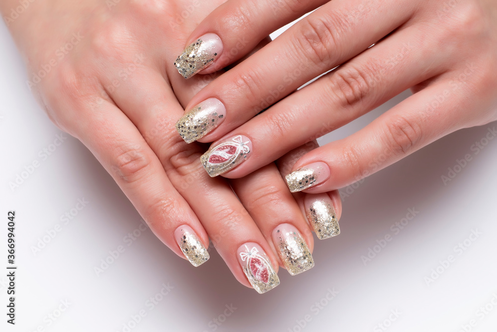 New Year's golden shiny manicure on long square nails close-up on a white background. Painting on nails. New Year's toys. New Year's golden shiny manicure on long square nails close-up on a white background. Painting on nails. New Year's toys.