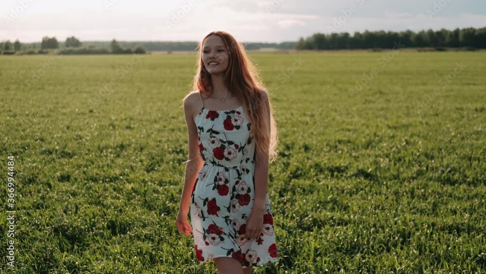 Happy red-haired woman whirls in a flowering field at sunset. Happy red-hair girl whirls around. Joy, beauty in nature and environment concept. Freedom concept. Happy red-haired woman whirls in a flowering field at sunset. Happy red-hair girl whirls around. Joy, beauty in nature and environment concept. Freedom concept.