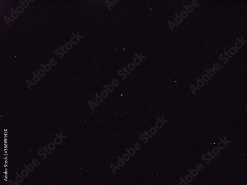 Flying dust particles on a black background. Stars in summer days 