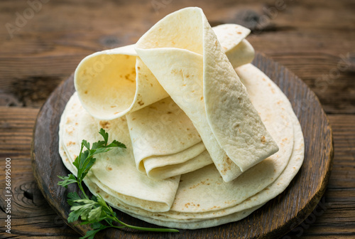Whole wheat flour tortilla on the wooden table background  photo