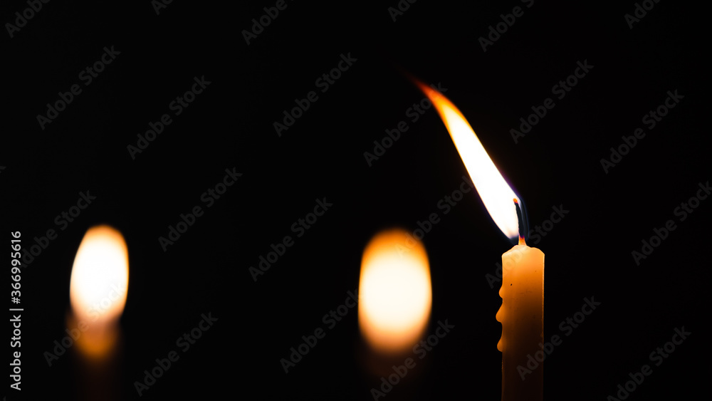 Close-up shots of yellow candles and lights on a black background with bokeh lights Close-up shots of yellow candles and lights on a black background with bokeh lights