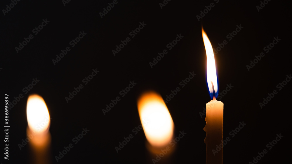 Close-up shots of yellow candles and lights on a black background with bokeh lights Close-up shots of yellow candles and lights on a black background with bokeh lights