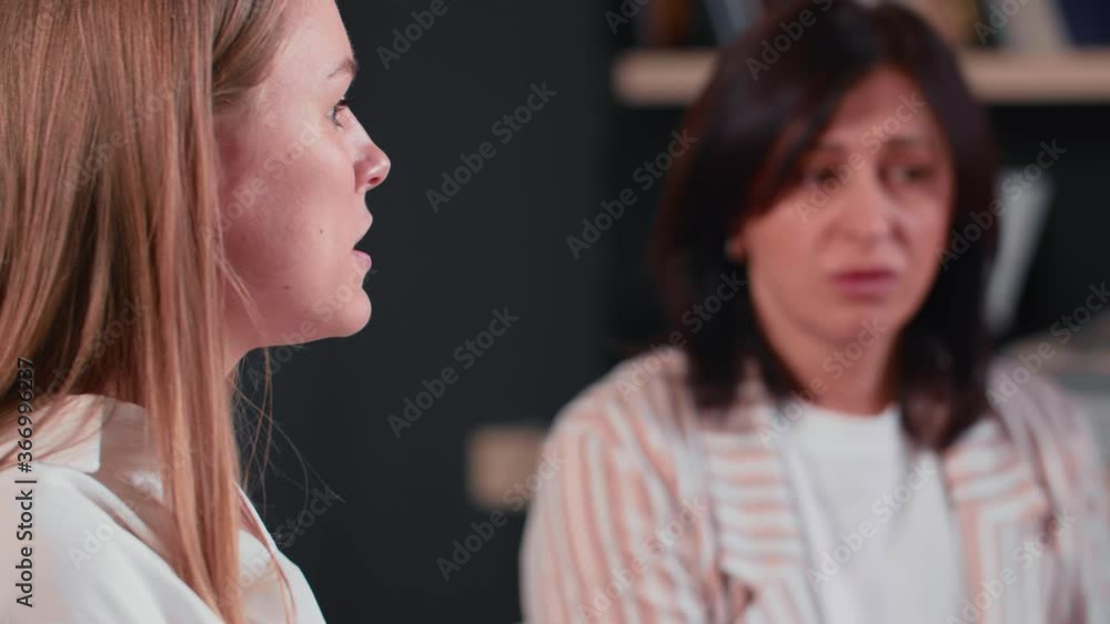 Age diversity at modern office. Focus shifts from beautiful Caucasian middle aged boss woman to younger colleague speak. Age diversity at modern office. Focus shifts from beautiful Caucasian middle aged boss woman to younger colleague speak.