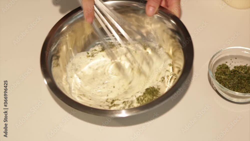Mayonnaise being mixed with seasoning in stainless steel bowl, front view Mayonnaise being mixed with seasoning in stainless steel bowl, front view