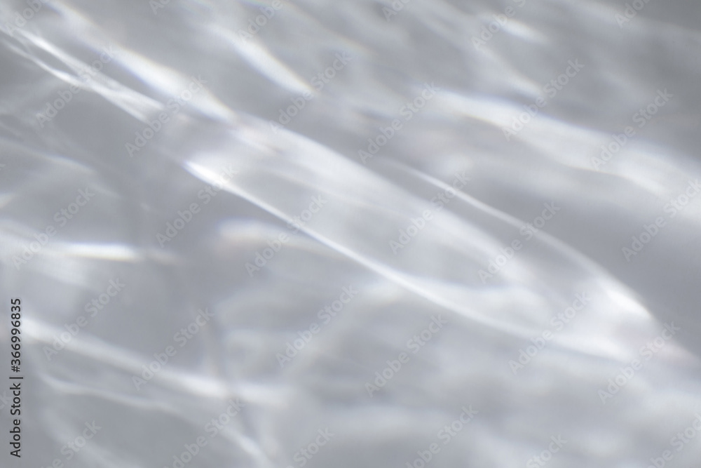 Fototapeta premium Blurred water texture overlay effect for photo and mockups. Organic drop diagonal shadow and light caustic effect on a white wall. Shadows for natural light effects