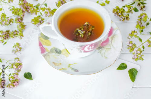 herbal medicinal tea with oregano flowers in a cup close-up. background with a cup of tea with oregano flowers macro.