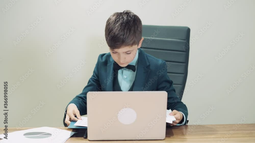 Handsome guy opens a folder with documents. There is a laptop on the table. Handsome guy opens a folder with documents. There is a laptop on the table.