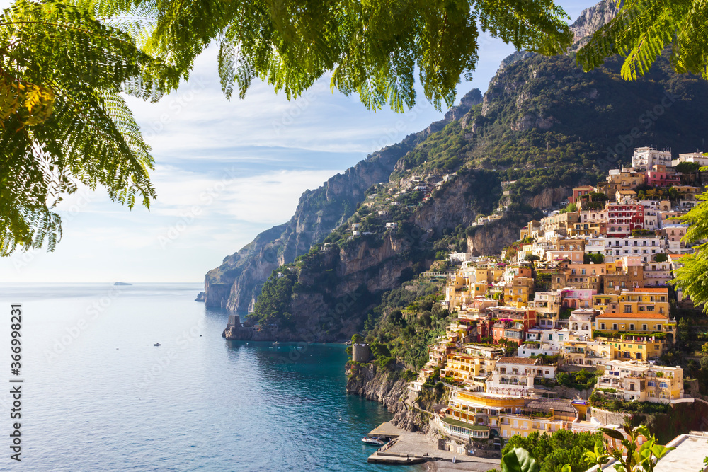 View through green leaves on the Colorful Positano town, the most famous place of the Amalfi Coast, South of Italy. 