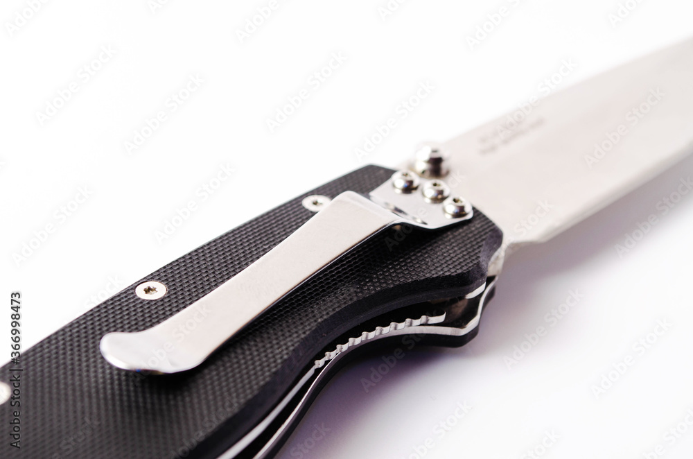 A folding knife with a black handle on a white background, open and closed. Paracord lanyard on the knife. Tactical folding knife in close-up A folding knife with a black handle on a white background, open and closed. Paracord lanyard on the knife. Tactical folding knife in close-up