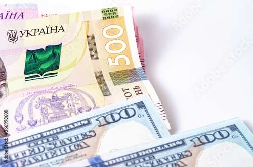 Banknotes Ukrainian hryvnia and dollars on a white background in close-up.