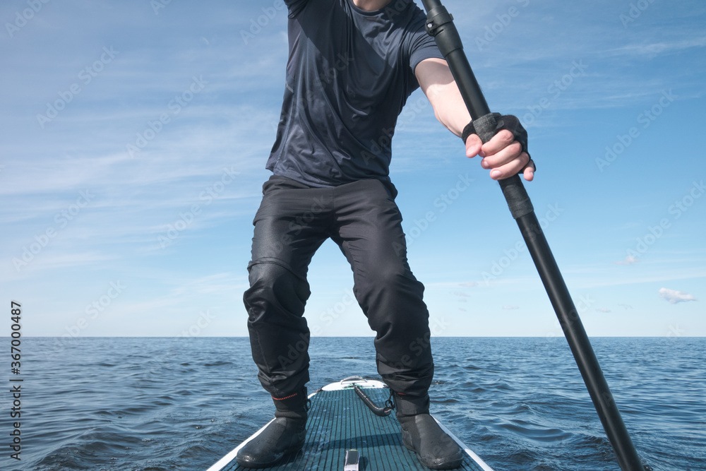 Surfer on a paddle board on the high seas Surfer on a paddle board on the high seas