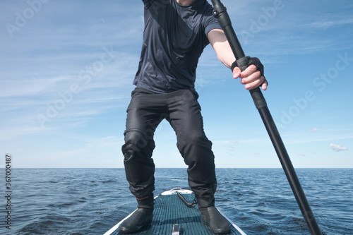 Surfer on a paddle board on the high seas photo