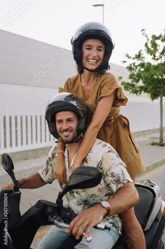 Beautiful young woman sitting behind her boyfriend on motorcycle