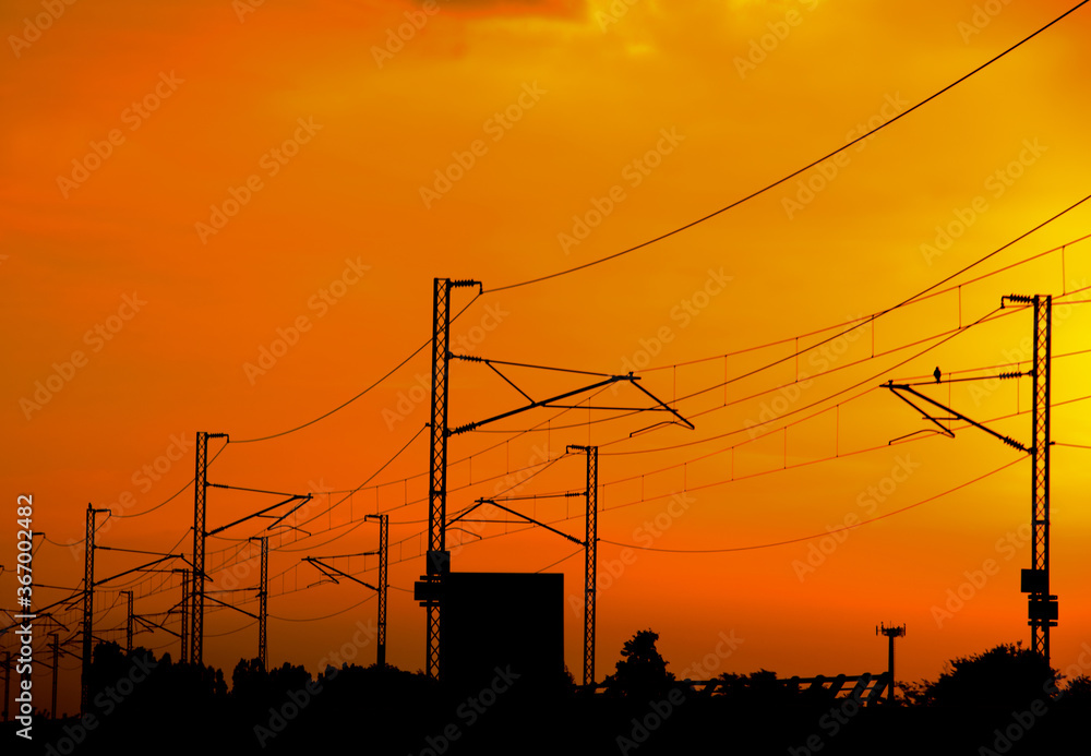 Silhouette High speed railway power line in perspective on  orange sky sunset or sunrise
