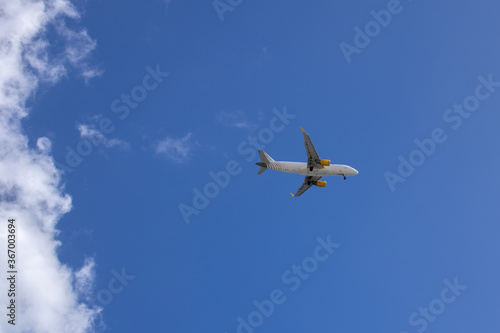 Commercial airplane with blue sky in the background and some clouds, approaching the runway at Fuerteventura airport