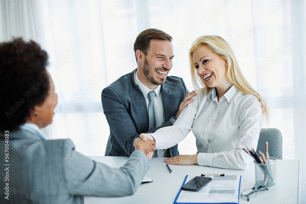 young couple shaking hands deal contract real estate investment business office agreement agent young couple shaking hands deal contract real estate investment business office agreement agent