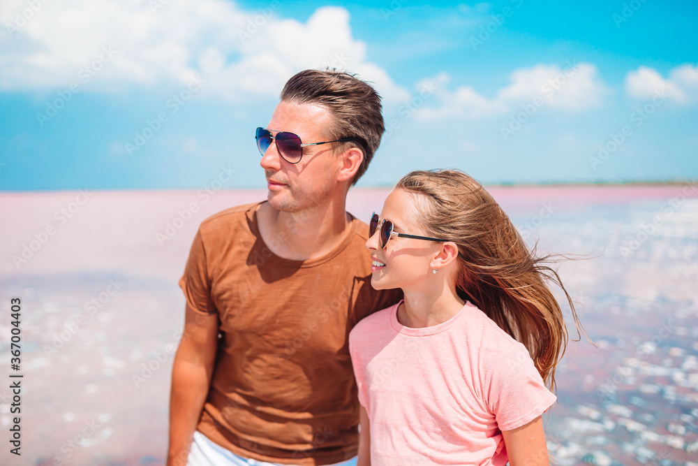 Little girl and happy dad having fun during beach vacation