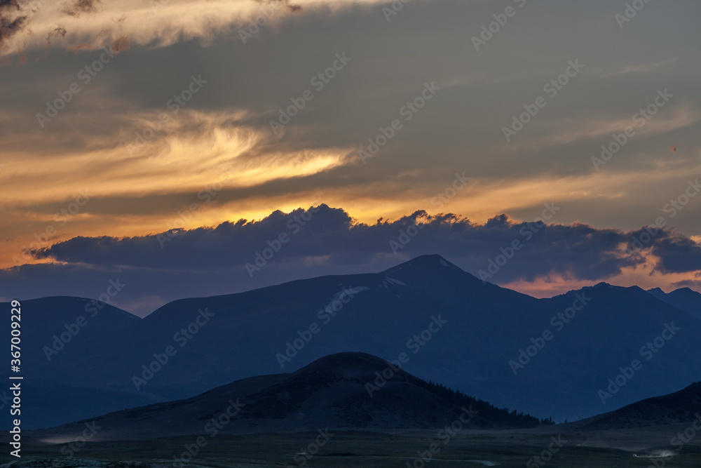 Mountain landscape at sunset. Outstanding view of the mountain ridges and clouds in Altai of Mongolia